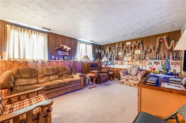 carpeted living room featuring a healthy amount of sunlight, a textured ceiling, and wooden walls