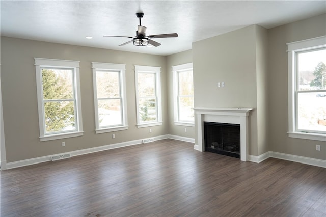 unfurnished living room featuring dark hardwood / wood-style flooring, plenty of natural light, and ceiling fan