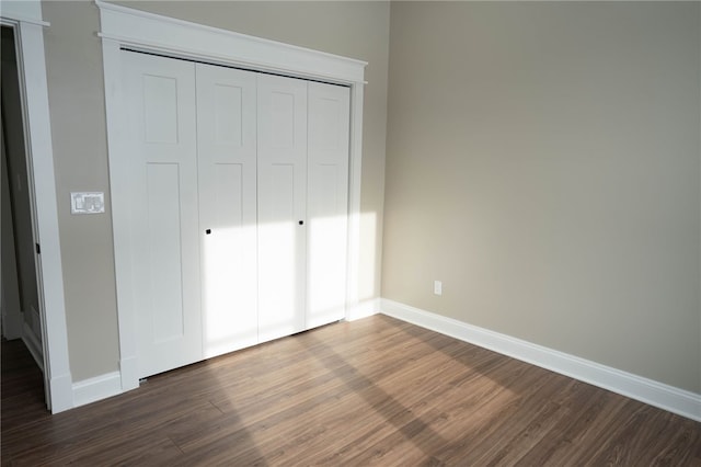 unfurnished bedroom with dark wood-type flooring