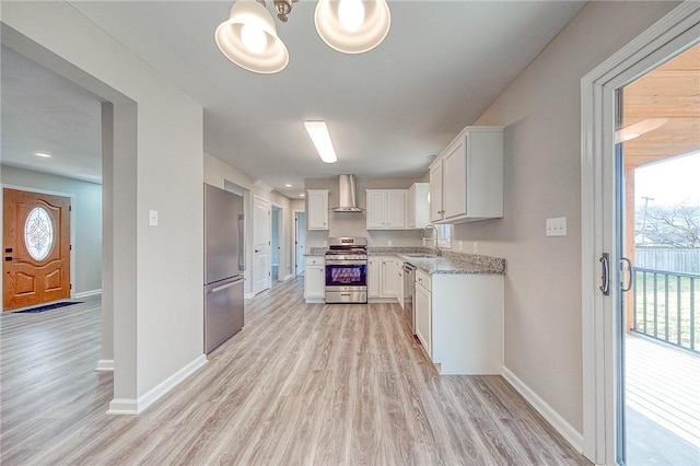 kitchen featuring wall chimney exhaust hood, stainless steel appliances, sink, light hardwood / wood-style floors, and white cabinetry