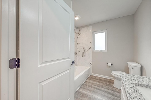 full bathroom featuring vanity, toilet, wood-type flooring, and bathing tub / shower combination