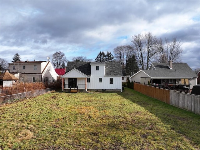 rear view of property featuring a lawn and a sunroom