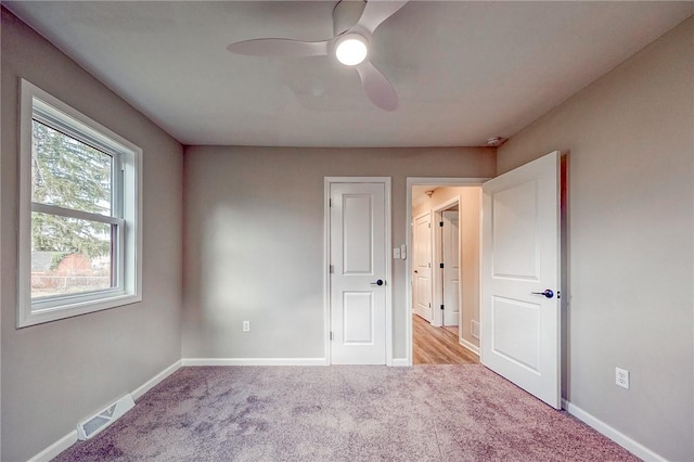 unfurnished bedroom featuring light carpet and ceiling fan