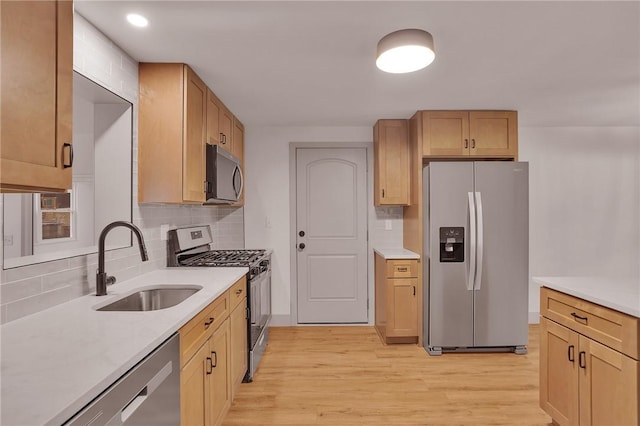 kitchen featuring backsplash, sink, light hardwood / wood-style flooring, stainless steel appliances, and light brown cabinetry