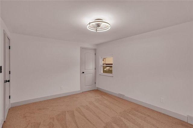 unfurnished room featuring light carpet