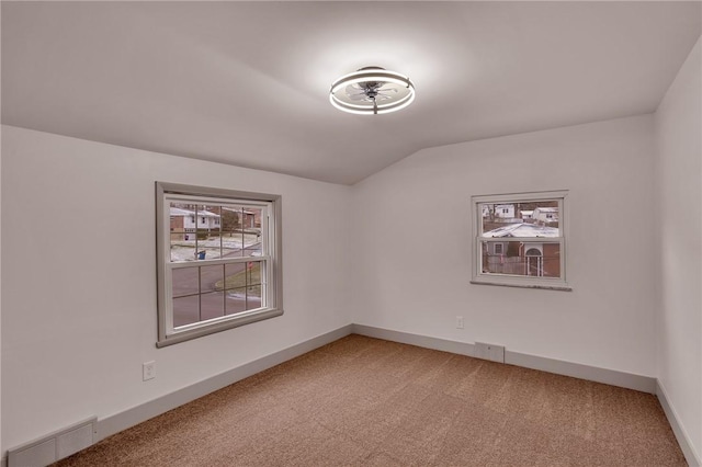 carpeted spare room featuring lofted ceiling