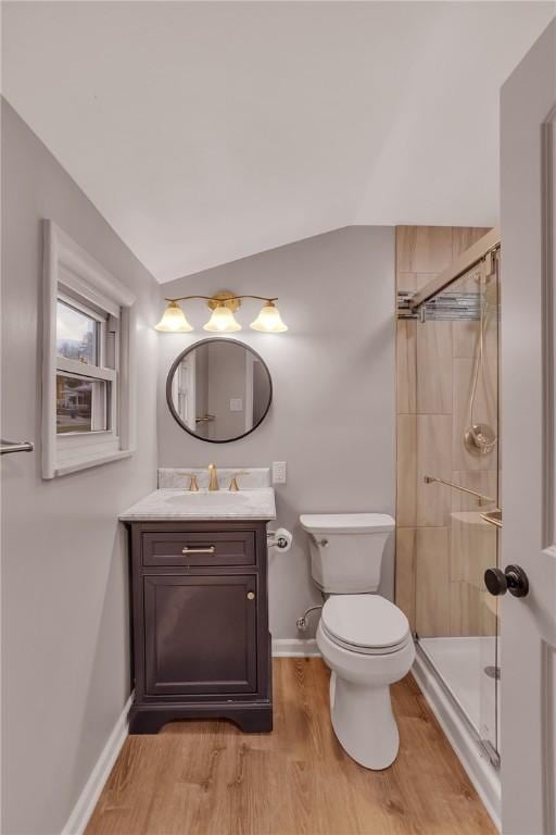 bathroom with toilet, a shower with shower door, wood-type flooring, vaulted ceiling, and vanity