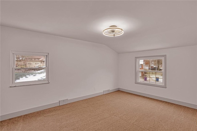 unfurnished room with carpet floors and vaulted ceiling