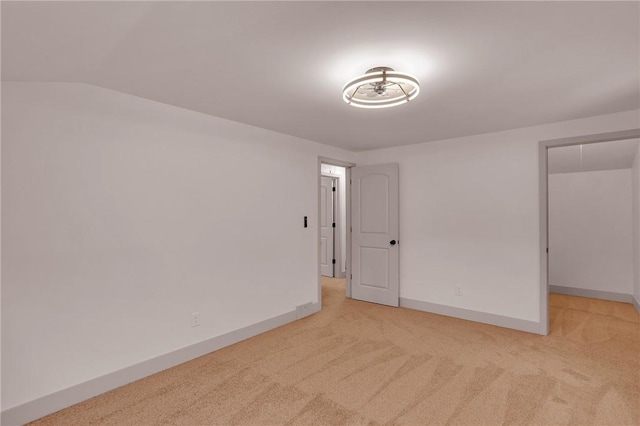 carpeted empty room featuring lofted ceiling