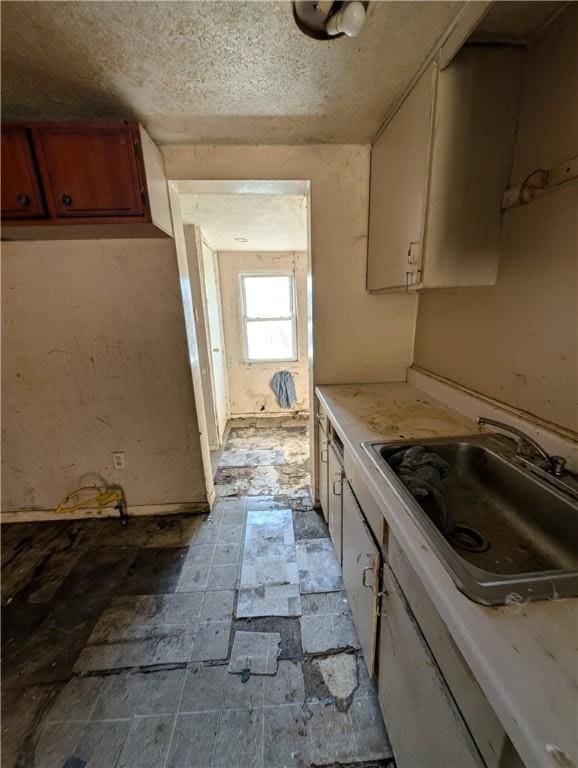 kitchen featuring a textured ceiling and sink