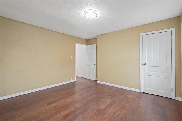 unfurnished bedroom featuring a textured ceiling, a closet, and dark hardwood / wood-style floors