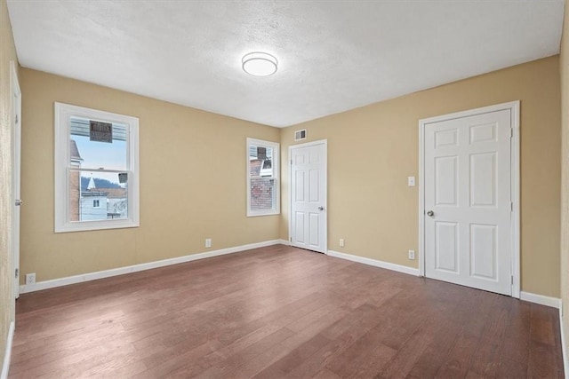 unfurnished bedroom with hardwood / wood-style floors and a textured ceiling