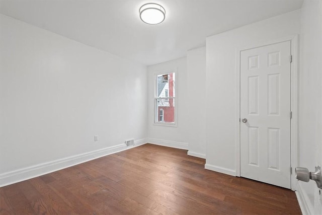 spare room with dark hardwood / wood-style floors