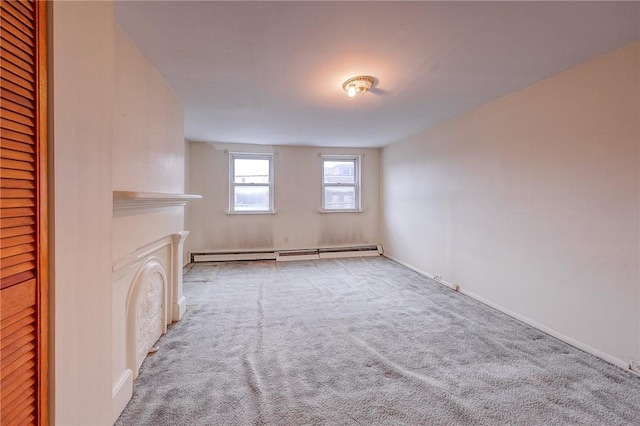 empty room with light carpet, a fireplace, and a baseboard radiator