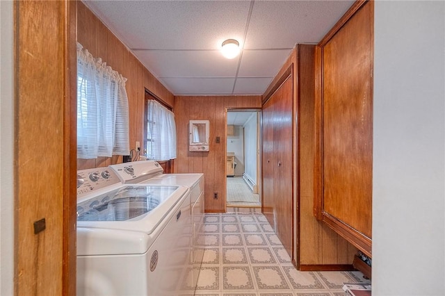 washroom featuring wooden walls, a baseboard heating unit, and independent washer and dryer