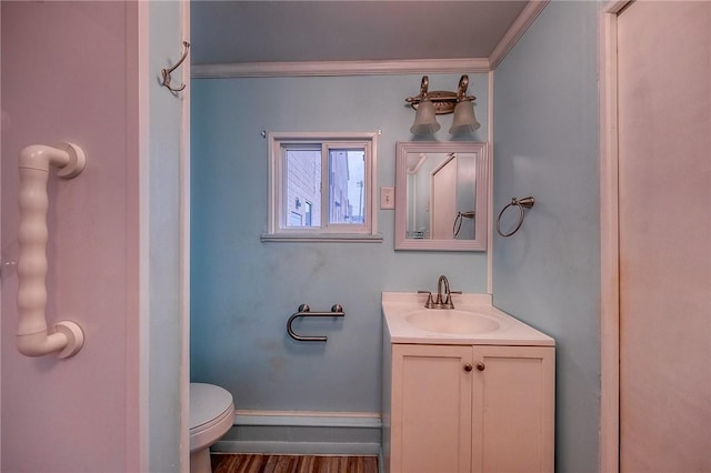 bathroom featuring vanity, toilet, ornamental molding, and wood-type flooring