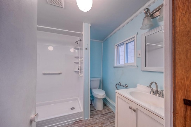 bathroom featuring vanity, crown molding, toilet, walk in shower, and wood-type flooring