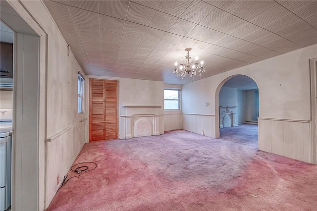 empty room with carpet floors and an inviting chandelier