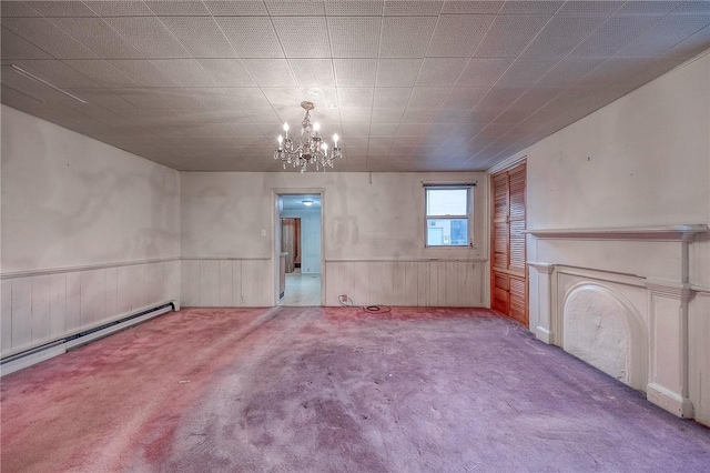 unfurnished living room with carpet floors, an inviting chandelier, and a baseboard heating unit