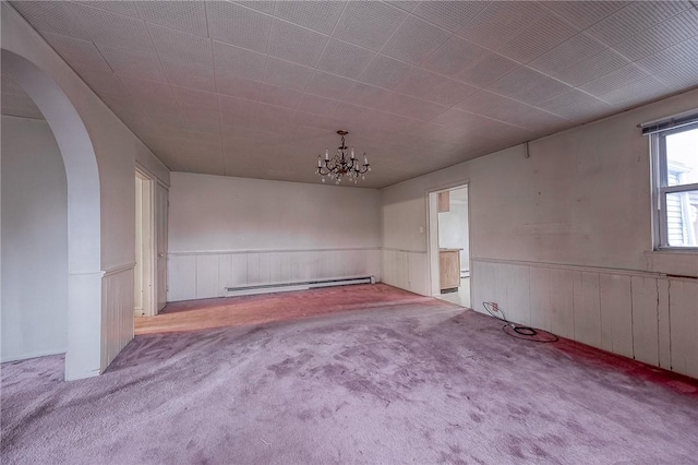 unfurnished room with a notable chandelier, light colored carpet, and a baseboard heating unit