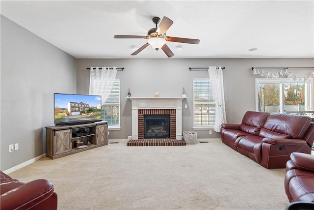 carpeted living room featuring ceiling fan, a healthy amount of sunlight, and a brick fireplace