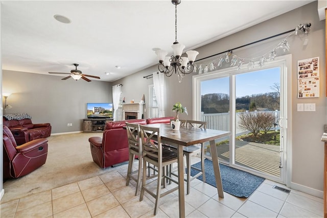 dining area featuring ceiling fan with notable chandelier and light tile patterned flooring