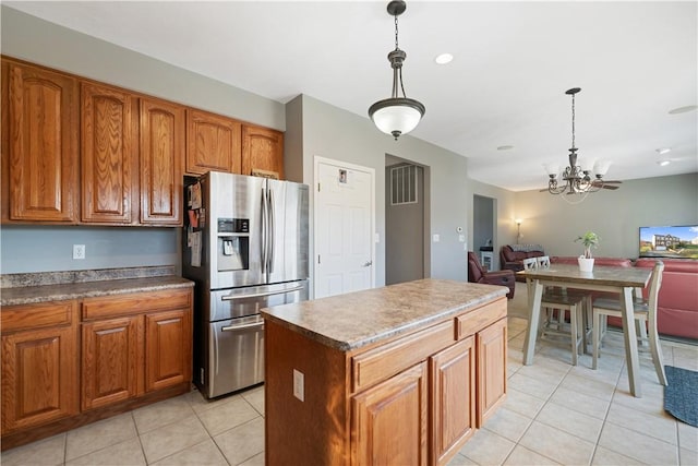 kitchen featuring light tile patterned flooring, a kitchen island, pendant lighting, and stainless steel refrigerator with ice dispenser