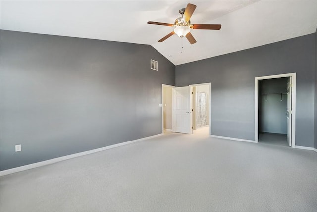 unfurnished bedroom featuring a walk in closet, ceiling fan, a closet, and light carpet