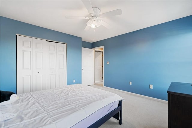 carpeted bedroom with ceiling fan and a closet