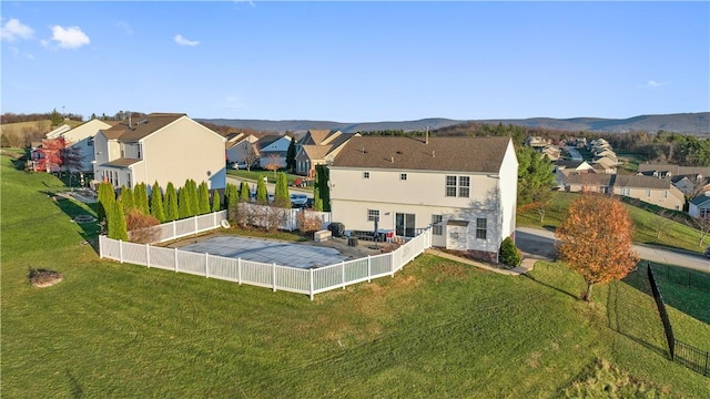 rear view of house with a mountain view and a yard