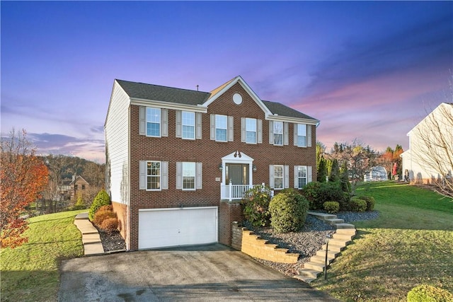 colonial home featuring a lawn and a garage