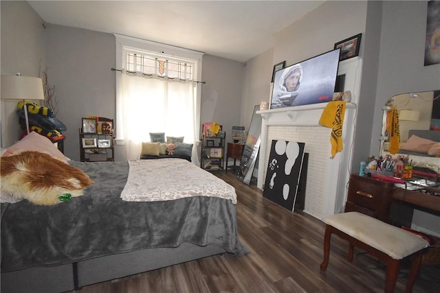 bedroom with a fireplace and dark hardwood / wood-style flooring