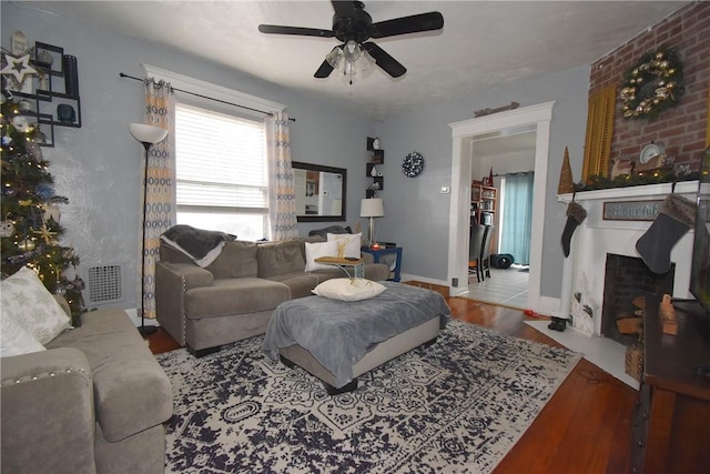 living room with hardwood / wood-style flooring, ceiling fan, and a fireplace