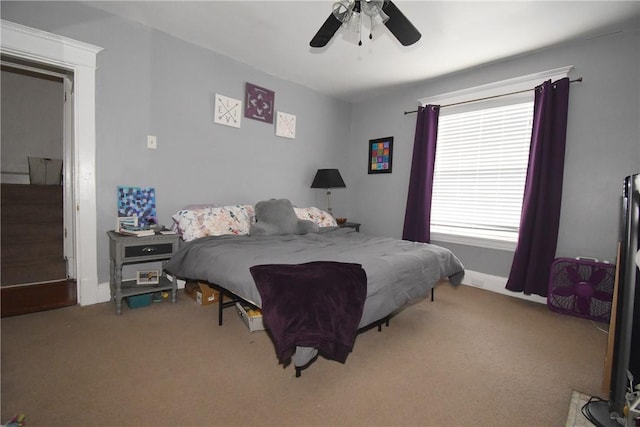 carpeted bedroom featuring multiple windows and ceiling fan