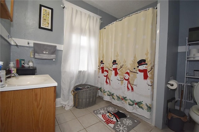 bathroom with toilet, a textured ceiling, vanity, and tile patterned floors