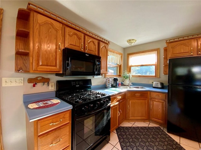 kitchen featuring light tile patterned floors, sink, and black appliances