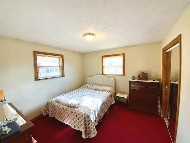 bedroom featuring dark carpet and a textured ceiling