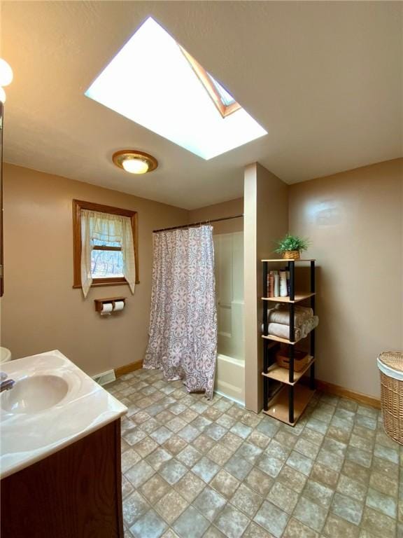 bathroom featuring vanity, a skylight, and shower / bath combo with shower curtain