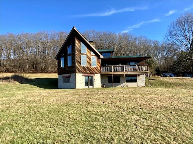 rear view of property featuring a deck and a yard