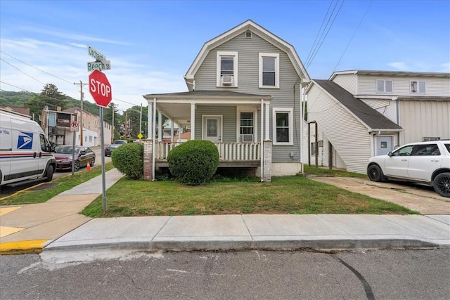 view of front of home with covered porch and a front lawn