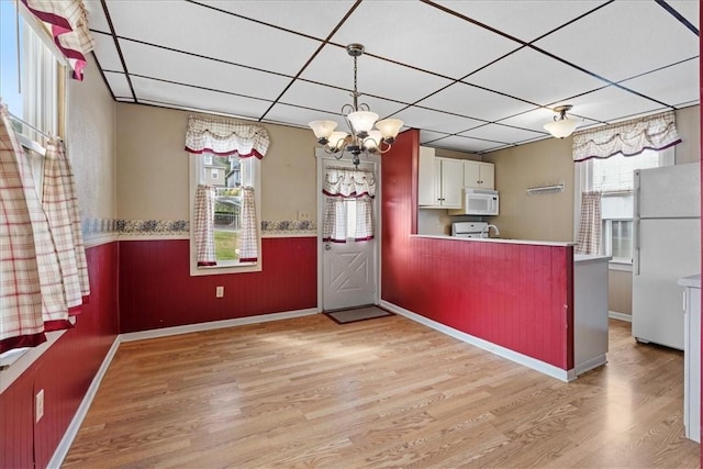 kitchen with white cabinetry, a chandelier, white appliances, light hardwood / wood-style floors, and a paneled ceiling