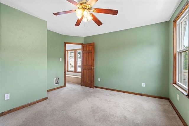 carpeted spare room with ceiling fan and a healthy amount of sunlight