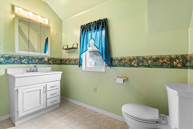 bathroom with toilet, vanity, and vaulted ceiling