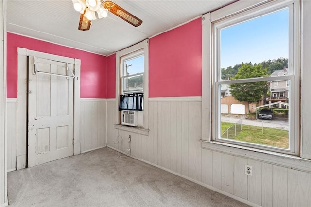 carpeted empty room featuring a wealth of natural light and ceiling fan