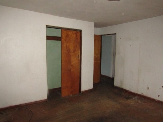 unfurnished bedroom with dark wood-type flooring