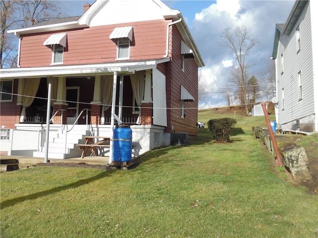 view of side of property featuring central AC and a yard