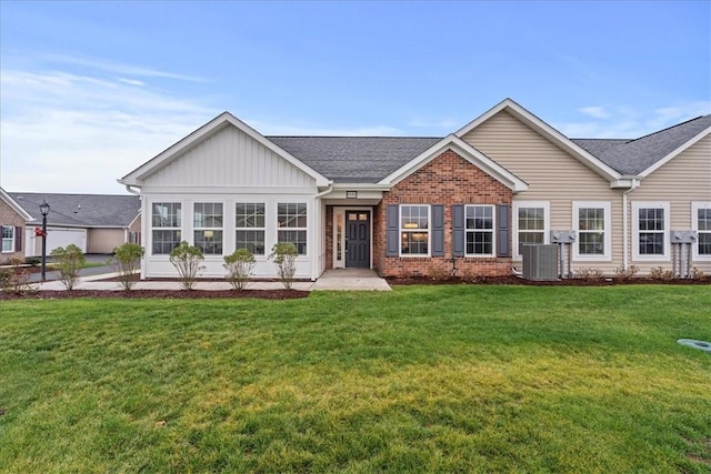 view of front of house with a front yard and central AC