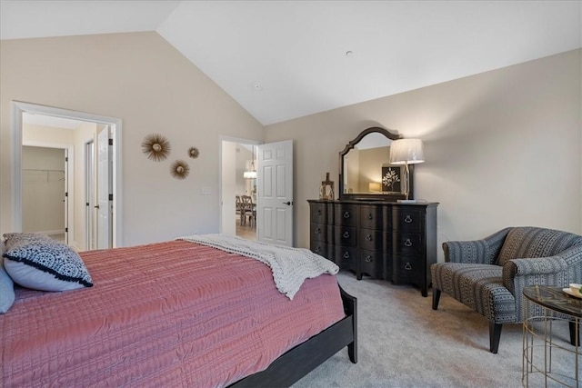 bedroom featuring light carpet, a closet, a spacious closet, and vaulted ceiling