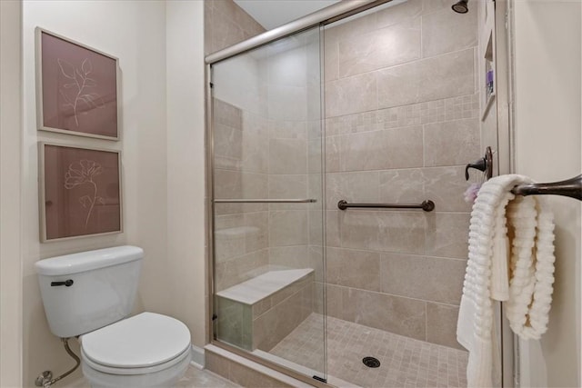 bathroom featuring toilet and a shower with shower door