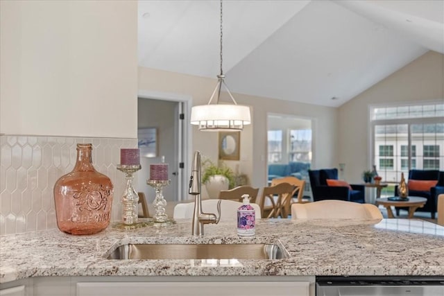 kitchen with sink, white cabinets, hanging light fixtures, and vaulted ceiling